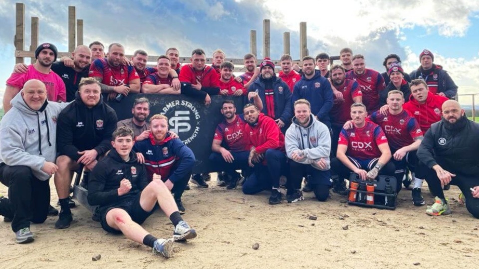 The Roughyeds players and staff take a break during their stint at Farmer Strong. Image courtesy of ORLFC