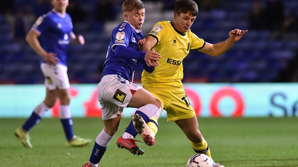 Harry Vaughan in action for Latics (left). Image courtesy of OAFC