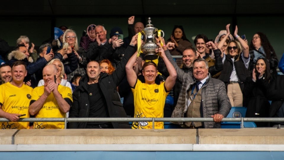 Dean Holden, captain of the Legends team, holding aloft the trophy after last year's charity game, which raised over £80,000