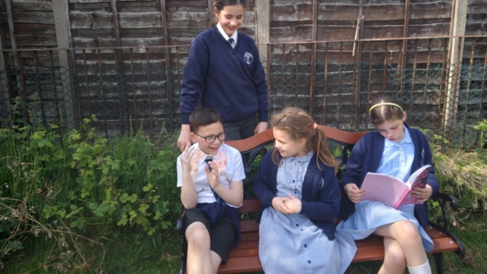 Christ Church children enjoy their new bench on the playing field