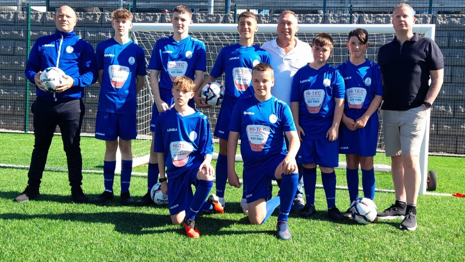 Proud Boundary Park Juniors players show off their new strips along with club chairman John Francis (back row, far left), Chadderton-born former England World Cup star David Platt (fourth from right), and his Golazzo business partner Scott Hannah (far right)