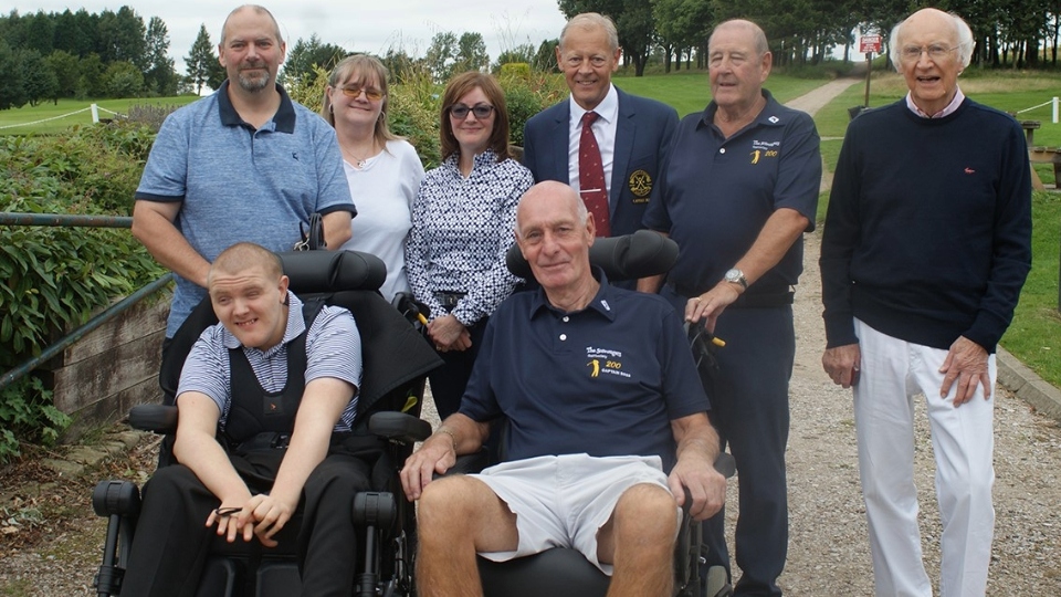 Pictured are (front row, in chairs): recipient Joseph Green and Paul Tennant, Scroungers Captain. Back row (left to right): Father Alan, Mother Sarah, Gail Taylor (Lady Captain, C+R), Dion Norbury (Captain, C+R), Syd Barton (Scroungers charity representative) and Peter Mitchell (wheelchair centre)