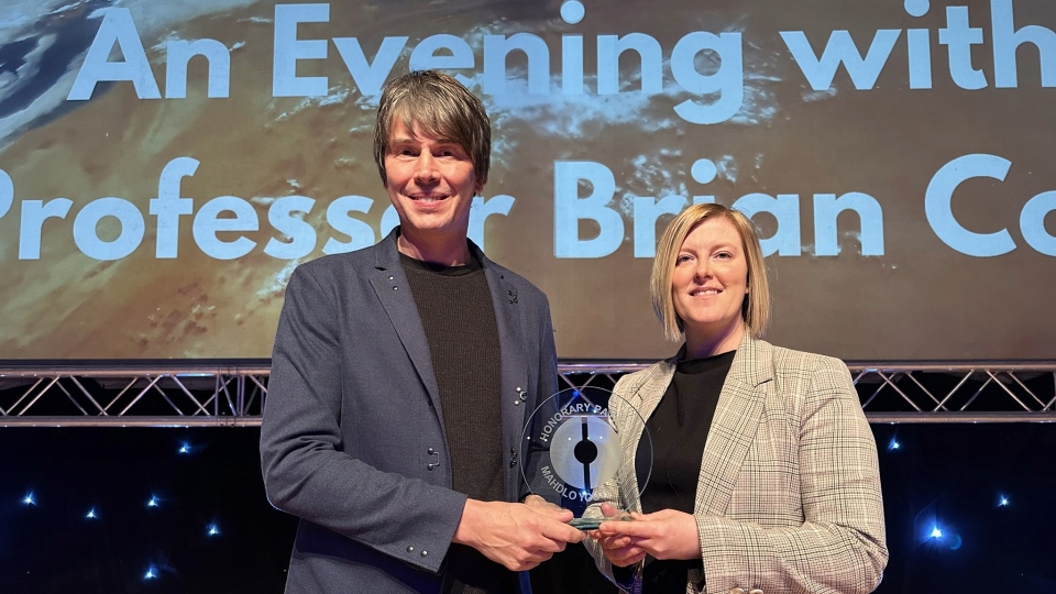 Lucy Lees, Mahdlo CEO, presents Professor Brian Cox with a memento of him becoming an Honorary Patron of the charity Lucy Lees, Mahdlo CEO, presents Professor Brian Cox with a memento of him becoming an Honorary Patron of the charity