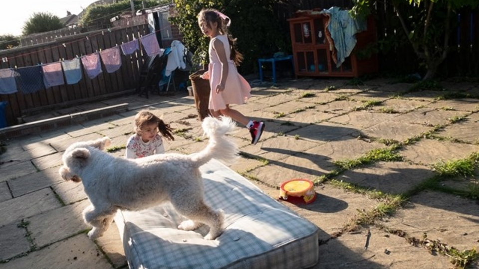 Hanan (right) and Rayan photographed by their mother, Ruba, while playing with a dog in their neighbour's garden. Image courtesy of the al-Hindawi family