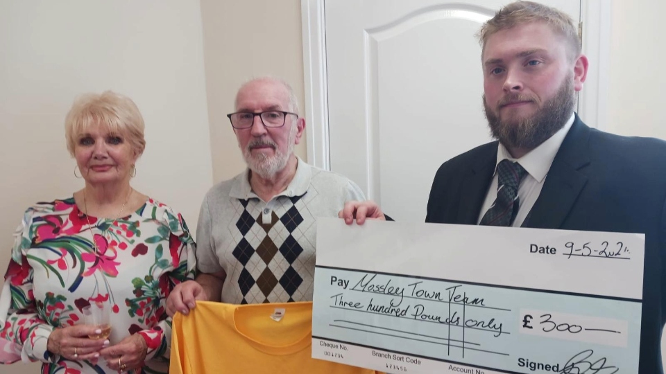 Funeral Director Ben McCutcheon presents a cheque to the Mossley Town Team Funeral Director Ben McCutcheon presents a cheque to the Mossley Town Team