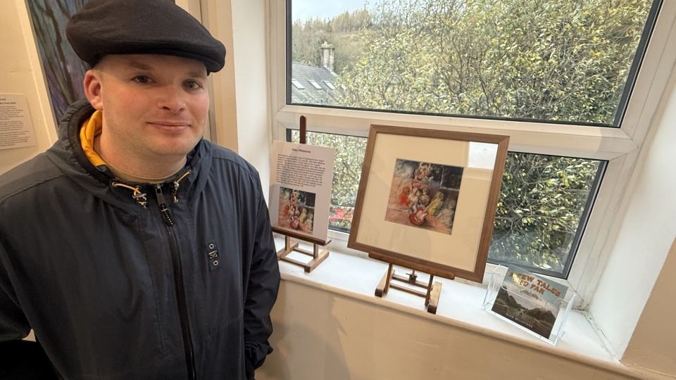 Kieran McMahon photographed in front of the display at the Millyard Art Gallery in Uppermill