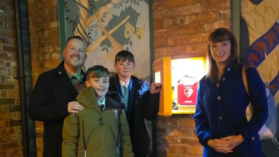 Scott Woodhead, Owner of Sports Physio UK and Co-Founder/Chairman of Defibrillators Save Lives, is pictured with his son Charlie, Sarah Hince and her son Tomas