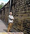 MISSING . . . Councillor Keith Begley with the remaining baskets and the bare wall 