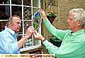 GLASS act . . . John McCombs, left, studies work produced by stained glass specialist John Orson, including a piece incorporating a butterfly from a magic lantern slide 
