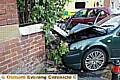 CRASH . . . a car driver being chased by police ends up in garden wall 
