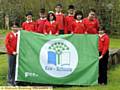 Roundthorn pupils proudly show off their Eco-Schools Green Flag. 
