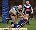 Hollinwood's Alistair Williams tries to force his way past Whinmoor opponents.