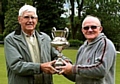 CUP OF JOY . . . Bob Carr (right) receives the McIntosh Cup from league president Bill Connelly.