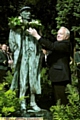 LOCAL hero: parish council chairman Brian Lord places a garland of white roses on the statue of poet Ammon Wrigley