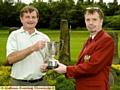 ALL YOURS: Mark Riley receives the Centenary Trophy from Saddleworth captain Tim Edwards. 