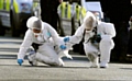 ON the scene . . . police forensic officers look for evidence 