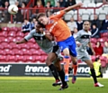 AIR RAID . . . Matt Smith beats Leon Legge to a header. 