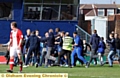 Fans invade the pitch and surround Jean-Yves Mvoto after his winning goal 
