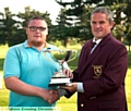 WELL DONE, CLUBMATE: Adam Rowbotham receives the District Championship trophy from Werneth captain James Buckley (right). 
