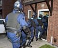 WAKE-UP call . . . officers storm into a property