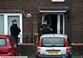 THE scene early this morning . . . the front door of the house smashed in as police ended the siege. 