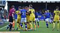 TEMPERS FRAY . . . a melee ensues between players from both sides after a challenge on Ryan McLaughlin

