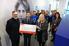 Oldham College students and staff hand over a £1,250 cheque to MP Jim McMahon