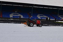 Staff and supporters help clear the snow at Boundary Park