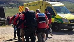 The casualty is helped into a waiting ambulance