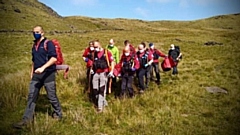 Members of Oldham Mountain Rescue team carrying the woman off Pots and Pans.