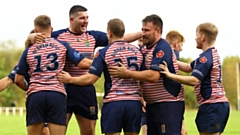 Oldham players celebrate one of their two tries at Wigan