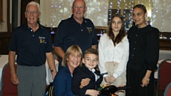 Klay receives his wheelchair with his family. Pictured are Scroungers officers (back, left to right): Captain Howard Barbour, Syd Barton, Levea Hughes and Eletha Hughes,  and (front) Gerry Gee and Klay
