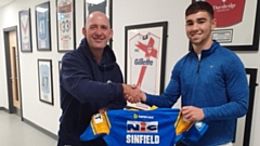 Jack Sinfield presents his team shirt to PE teacher Gary Melling