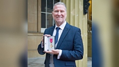 Graham Quinn, the CEO at the Oldham-based New Bridge Multi Academy Trust, pictured with his OBE at Buckingham Palace