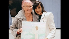 Visiting Angels Managing Director Roxie Taj is pictured with warm-hearted client Sheina Burns, and her painting