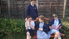 Christ Church children enjoy their new bench on the playing field