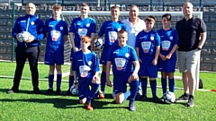 Proud Boundary Park Juniors players show off their new strips along with club chairman John Francis (back row, far left), Chadderton-born former England World Cup star David Platt (fourth from right), and his Golazzo business partner Scott Hannah (far right)