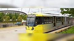 A Metrolink tram goes past the Etihad stadium. Image courtesy of TfGM