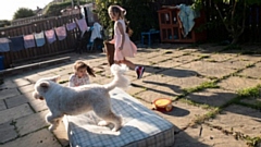 Hanan (right) and Rayan photographed by their mother, Ruba, while playing with a dog in their neighbour's garden. Image courtesy of the al-Hindawi family