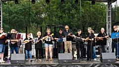 The Mossley Ukulele Group pictured on stage