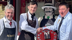 Paul H Walsh presents the annual “Paul Peacock” Sausage of the Year trophy to Lee and his son Ben, who made the winning “Welsh Dragon” pork chilli and leek sausage