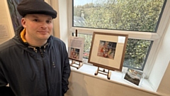 Kieran McMahon photographed in front of the display at the Millyard Art Gallery in Uppermill